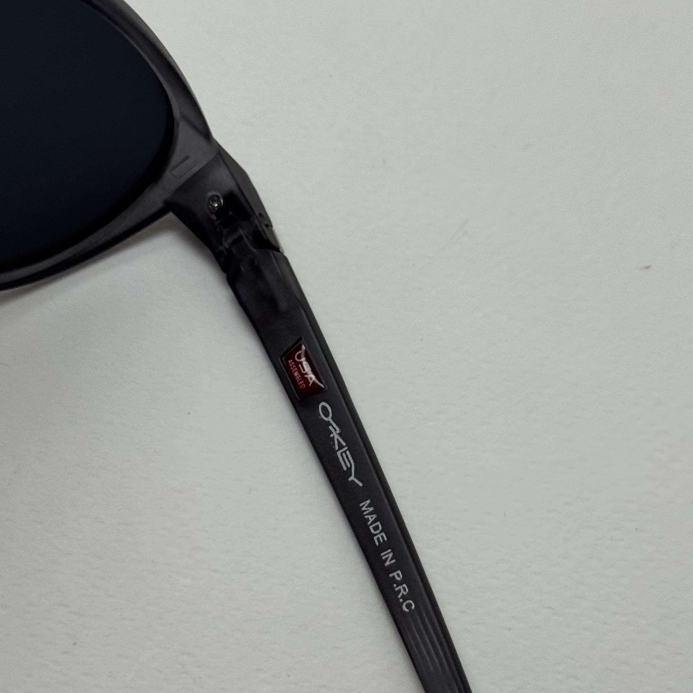 عینک آفتابی پلاریزه اوکلی Oakley طوسی عدسی مشکی گرد کد TO4910