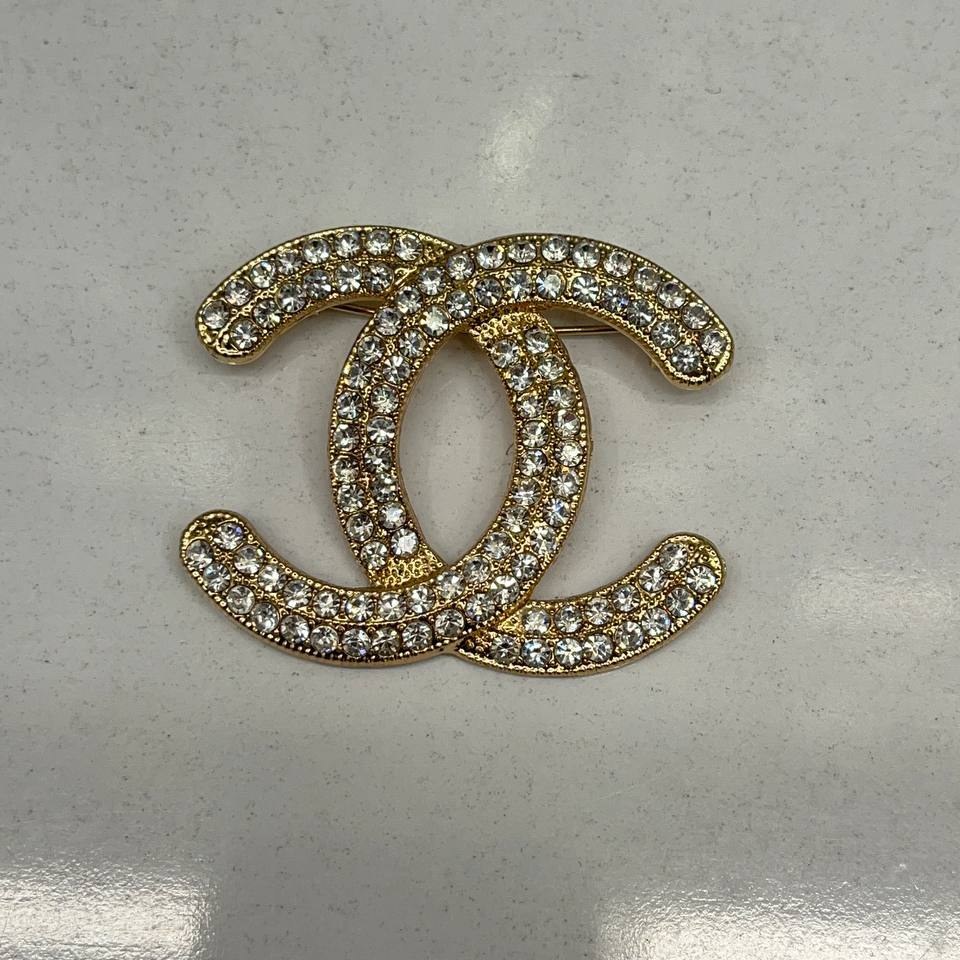 گل سینه نگین جواهری مدل شنل Chanel طلایی تنوع طرح رنگ کاملا ثابت کد bn (پس کرایه)